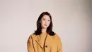 Yoona mengenakan pakaian serba kuning dipadukan knee boots hitamnya saat hadir di Miu Miu. [@miumiu]