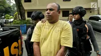 Pelaku pengeroyokan dan penganiayaan, Edwin Hitipeuw dikawal oleh polisi saat dibawa ke Polda Metro Jaya, Jakarta (12/7). Dari hasil pemeriksaan sementara, penganiayaan dilakukan karena motif bersenggolan mobil di jalan Tol Jagorawi. (Liputan6.com/Pool)