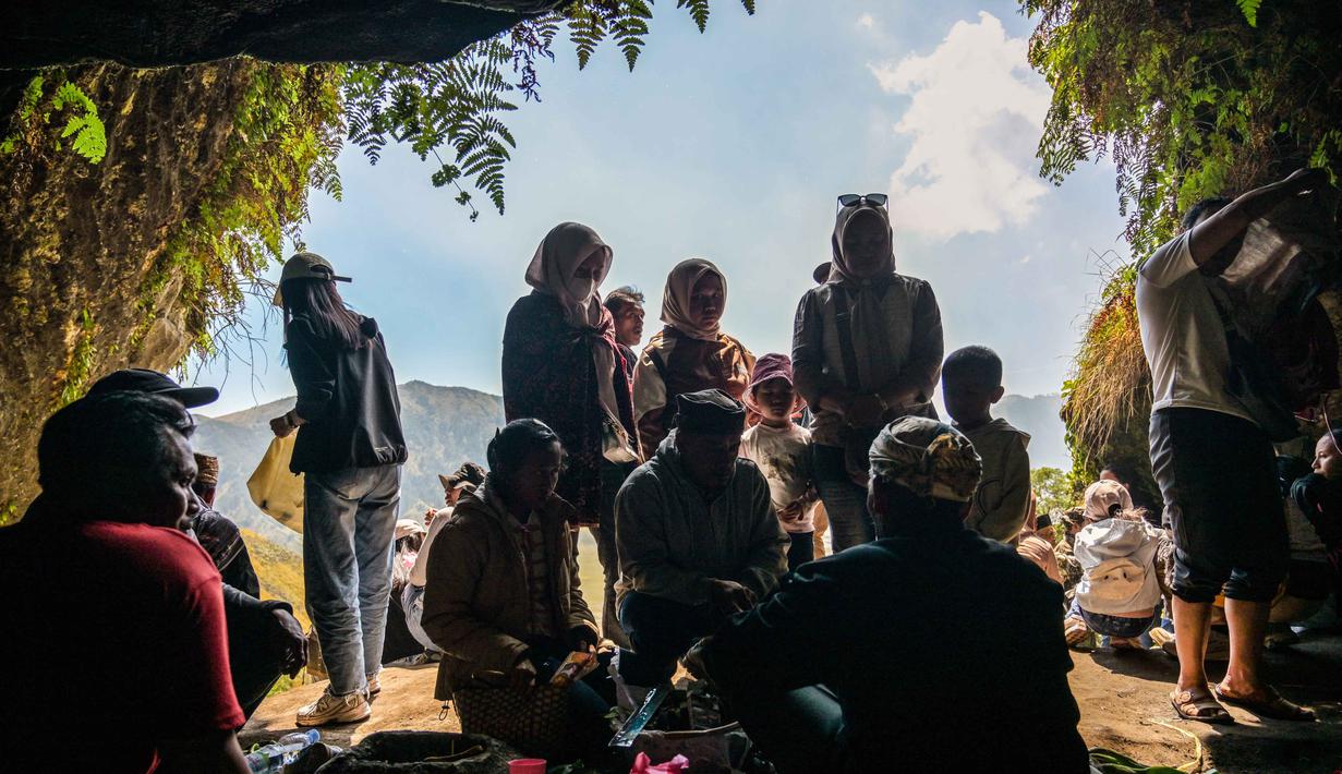 Orang-orang berdoa dan memberkati di gua Widodaren menjelang upacara Yadnya Kasada di Pasuruan, di kaki Gunung Bromo, Jawa Timur, pada Minggu 31 Mei 2026. (JUNI KRISWANTO/AFP)
