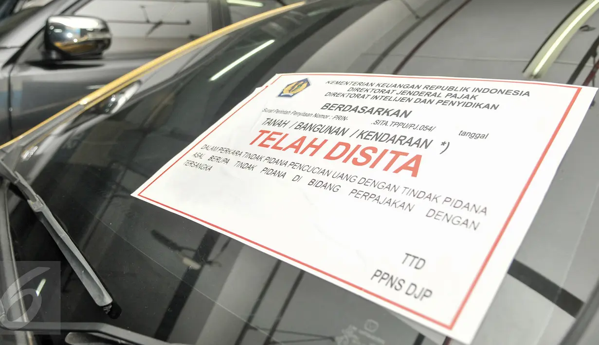 Stiker penyitaan ditempel di kaca mobil terkait kasus dugaan tindak pidana pencucian uang (TPPU) di Kantor Pusat Dirjen Pajak, Jakarta, Kamis (26/1). (Liputan6.com/Yoppy Renato)