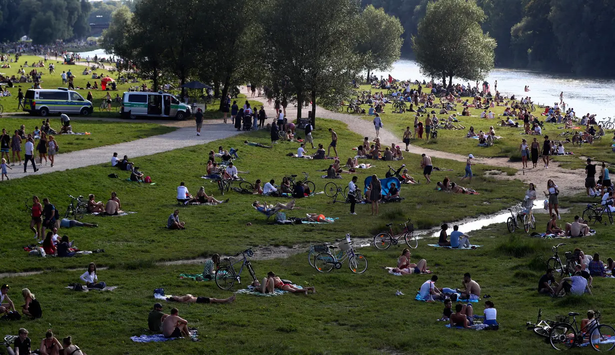 Ribuan orang menikmati cuaca musim panas di tepi sungai 'Isar' di Munich, Jerman (19/7/2020). Di tengah pandemi COVID-19, ribuan orang menikmati cuaca musim panas di dekat sungai tersebut untuk berjemur serta mendinginkan tubuh. (AP Photo/Matthias Schrader)