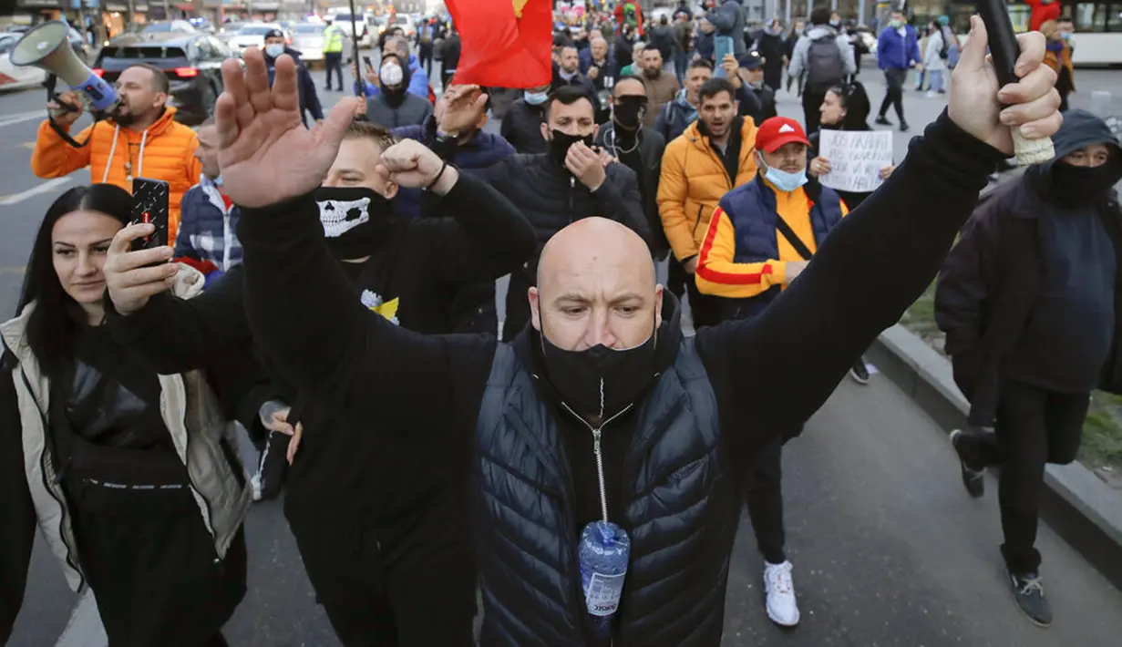 Warga yang memprotes pembatasan terkait pandemi COVID-19 berbaris di pusat Kota Bucharest, Rumania, Senin (29/3/2021). Ribuan pengunjuk rasa antipembatasan turun ke jalan di beberapa kota Rumania sehari setelah langkah pembatasan baru diberlakukan. (AP Photo/Vadim Ghirda)