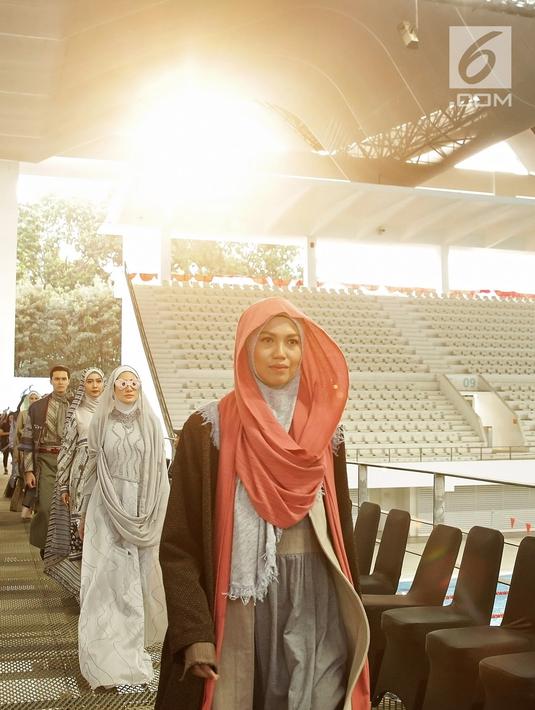 Model berjalan di catwalk pada pembukaan Muffest) 2020 di Aquatic Stadium, GBK Senayan, Jakarta, Jumat (30/8/2019). Muffest mempertemukan para pelaku industri busana muslim tanah air, baik yang sudah punya nama dan brand besar, maupun dari pelaku usaha kecil dan menengah. (Fimela.com/Bambang E.Ros)