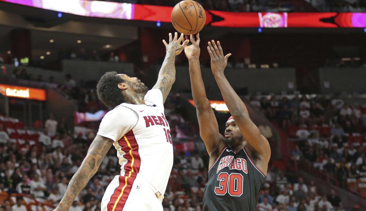 Aksi pemain Chicago Bulls, Noah Vonleh (30) melakukan tempabakan saat diadang pemain Miami Heat pada laga NBA basketball game, di American Airlines Arena, Miami, (29/3/2018). Heat menang 103-92. (AP/Joel Auerbach)
