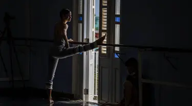 Seorang penari Balet Nasional Kuba melakukan peregangan sebelum berlatih di sekolah balet di Havana, Kuba, Selasa (5/4/2022). Balet Nasional Kuba memulai latihan untuk kembali ke panggung setelah lebih dari setahun setelah pandemi COVID-19 ditutup. (AP Photo/Ramon Espinosa)