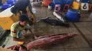Pekerja mempersiapkan ikan di Pasar Ikan Modern Muara Baru, Jakarta, Jumat (8/10/2021). Nelayan Muara Baru menghentikan aksi mogok bongkar muat terkait penolakan PP No 85 Tahun 2021 mengenai naiknya tarif Penerimaan Negara Bukan Pajak (PNBP) sektor perikanan. (Liputan6.com/Herman Zakharia)