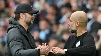 Manajer Liverpool Jerman Jurgen Klopp (kiri) berjabat tangan dengan Manajer Manchester City Spanyol Pep Guardiola setelah pertandingan Liga Inggris di Etihad Stadium, Manchester, Minggu, pada 10 April 2022. Pertandingan berakhir 2-2. (foto: Paul ELLIS / A