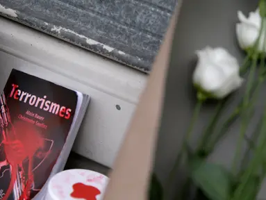 Karangan bunga dan buku di letakan sebagai penghormatan kepada korban serangan teroris di Paris, di Perancis di Perancis (14/11/2015). Serangan teroris yang terjadi di Paris telah menewaskan sekitar 140 orang. (AFP PHOTO/KENZO TRIBOUILLARD)