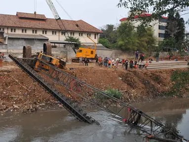 Crane untuk memasang turap di bantaran Kali Kampung Pulo jatuh ke Sungai Ciliwung (1/10/15) dan menimpa gubuk. Akibatnya, seorang warga RT15/10 Kelurahan Bukit Duri, Jakarta Selatan harus mendapatkan perawatan medis. (Liputan6.com/Gempur M Surya)