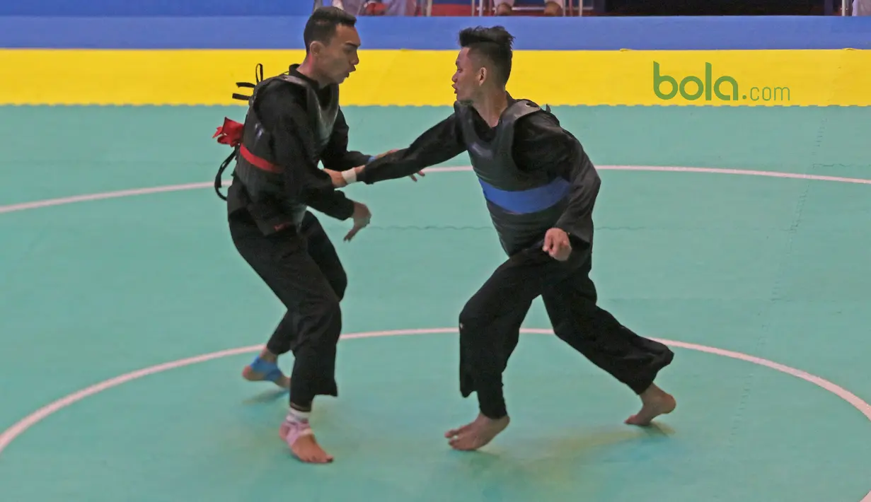 Arafa M. Yachser (kiri) menghalau pukulan pesilat Malaysia, Shukor Mohamad Zarish Hakim pada semifinal putra kelas 55 kg - 60 kg Test Event Pencak Silat 2018 di Padepokan Silat TMII, Jakarta, (12/2/2018). Arafa menang 5-0. (Bola.com/Nick Hanoatubun)
