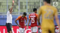 Pemain Borneo FC Samarinda Hendro Siswanto menerima kartu merah dari wasit Fariq Hitaba setelah melanggar pemain Bhayangkara Solo FC TM Ichsan dalam pertandingan babak penyisihan Piala Menpora 2021 di Stadion Kanjuruhan, Malang, Jawa Timur, Senin (22/3/2021). (Bola.com/Arief Bagus)