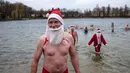 Anggota klub renang "Berliner Seehunde" (Berlin Seals) keluar dari danau Orankesee sebagai bagian dari tradisi berenang pada Natal di Berlin, Senin (25/12). Kegiatan ini salah satu tradisi di Berlin menyambut Natal setiap tahun. (AP/Markus Schreiber)