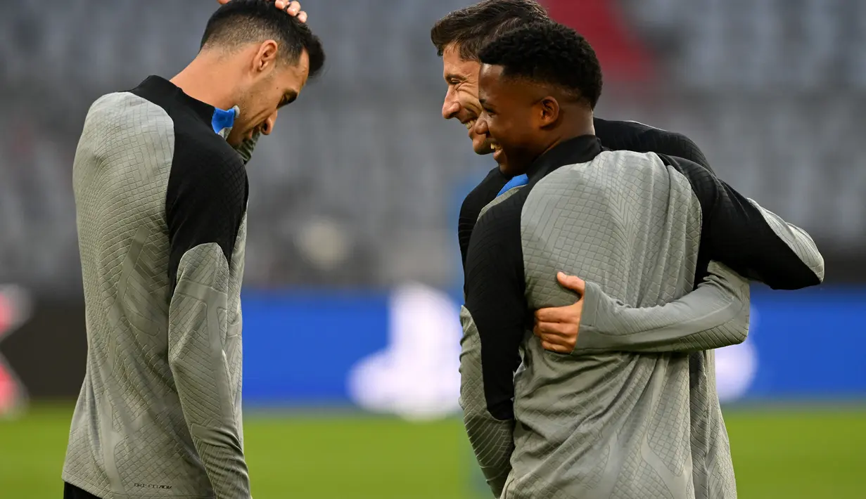 Penyerang Barcelona, Ansu Fati (kanan) bersama rekan setimnya Sergio Busquets dan Robert Lewandowski menghadiri sesi latihan tim di Munich, Jerman selatan (12/9/2022). Barcelona kini berada di posisi pertama klasemen sedangkan Munchen berada di peringkat kedua dengan tiga poin yang sama. (AFP/Christof Stache)