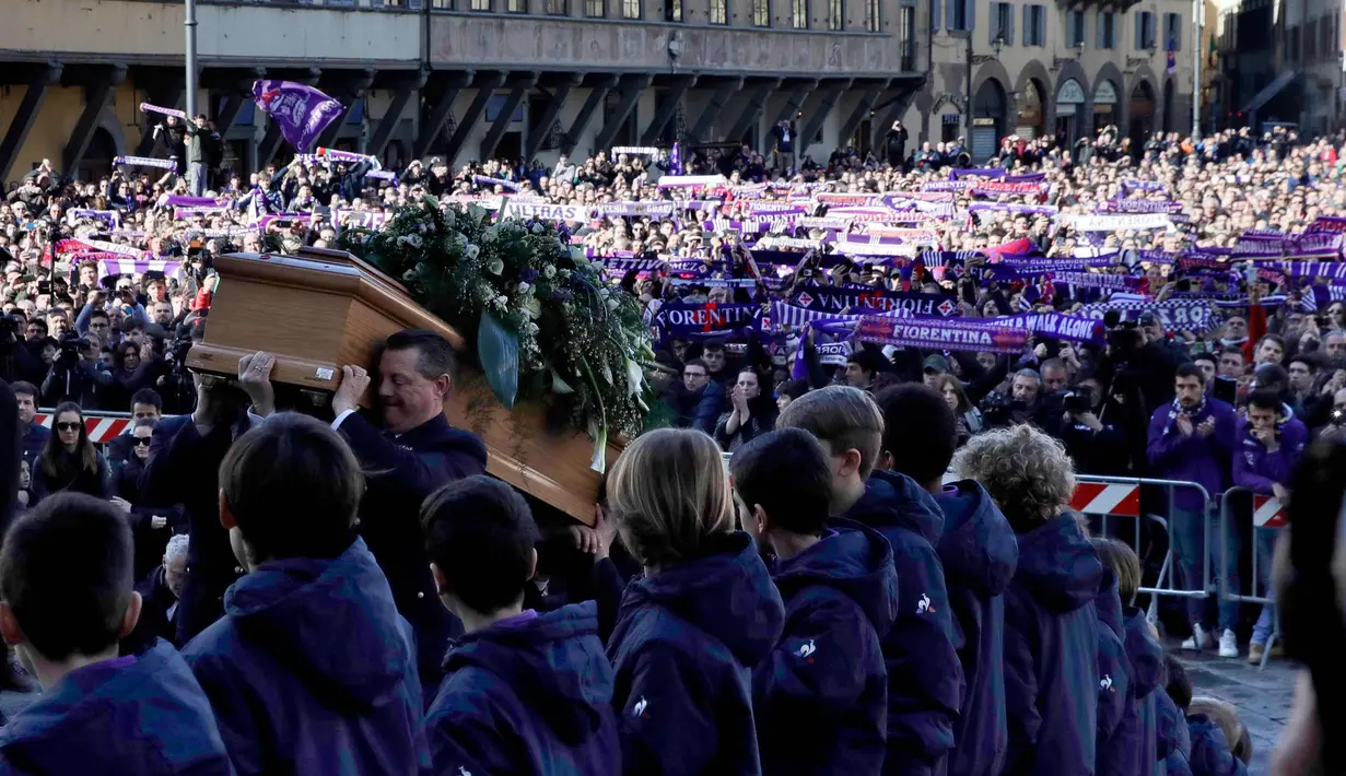 Suporter Fiorentina membentangkan syal saat mengantar jenazah kapten Fiorentina Davide Astori pada upacara pemakaman di Florence, Italia (8/3). Davide Astori meninggal pada usia 31 tahun. (AP Photo/Alessandra Tarantino)