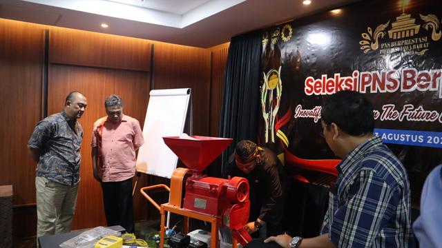 Ahmad Nasir Ginanjar (38), penyuluh pertanian Dinas Pertanian Kabupaten Garut, Jawa Barat, mesin mini huller padi portabel berbahan gas tengah menjelaskan di depan juri loma ASN Berprestasi tingkat Jawa Barat. (Liputan6.com/Jayadi Supriadin)