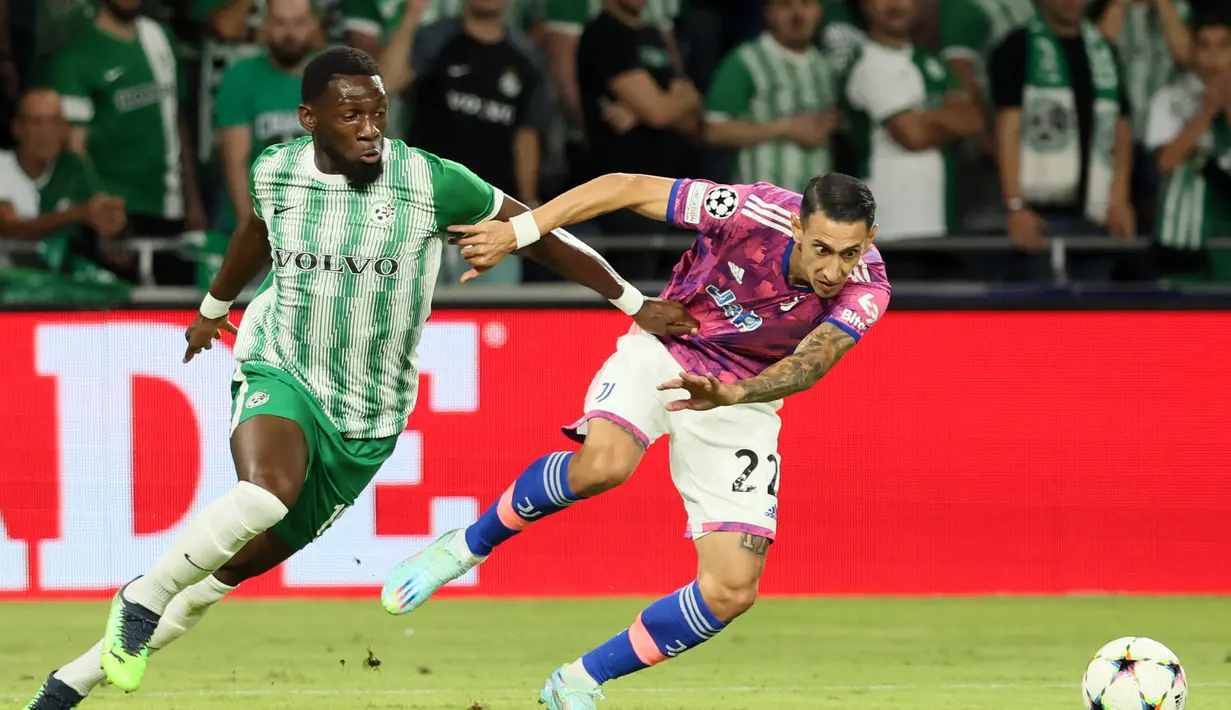 Penyerang Juventus, Angel Di Maria berebut bola dengan bek Maccabi Haifa, Dylan Batubinsika selama pertandingan lanjutan grup H Liga Champions di stadion Sammy Ofer di kota Haifa pada 11 Oktober 2022. Maccabi Haifa menang atas Juventus 2-0. (AFP/JACK GUEZ)