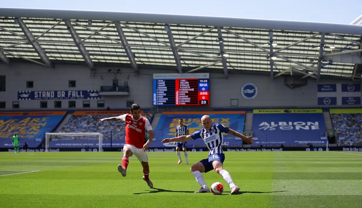 Gelandang Arsenal, Dani Ceballos (kiri) berusaha merebut bola dari pemain Brighton & Hove Albion, Aaron Mooy pada lanjutan pertandingan Liga Inggris di The American Express Community Stadium, Sabtu (20/6/2020). Sempat unggul, Arsenal tumbang 1-2 di tangan Brighton. (Richard Heathcote/POOL/AFP)