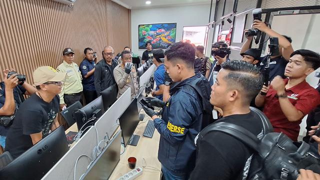 Polisi menggeledah sebuah ruko di Grand Galaxy, Jalan Garden Kota Bekasi pada Jumat (1/11/2024). Penggerebekan ini terkait dengan kasus judi online yang melibatkan pegawai dan staf ahli di Kementerian Komunikasi dan Digital atau Komdigi.
