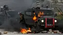 Tentara Israel meninggalkan kendaraan yang terbakar oleh lemparan bom molotov warga Palestina di pinggiran Kota Ramallah, Tepi Barat, Rabu (27/3). Bentrokan ini sebagai bentuk protes terhadap tahanan Palestina yang berada di Israel. (AP Photo/Majdi Mohammed)