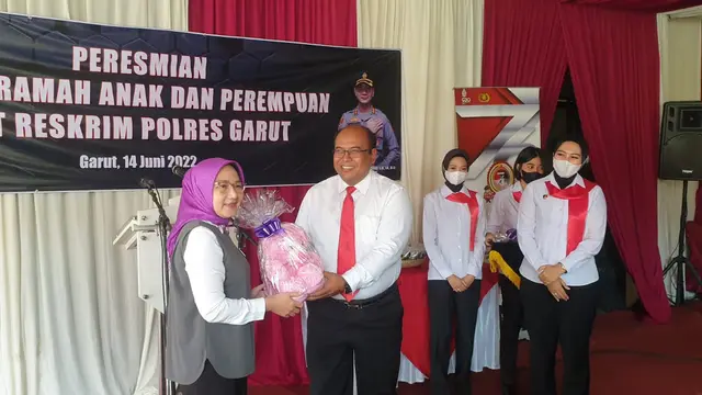 Kasatreskrim Polres Garut AKP Dede Sopandi menerima cenderamata berupa boneka dari Komnas PA Jawa Barat di sela-sela peresmian ruang ramah anak dan perempuan polres Garut. (Liputan6.com/Jayadi Supriadin)