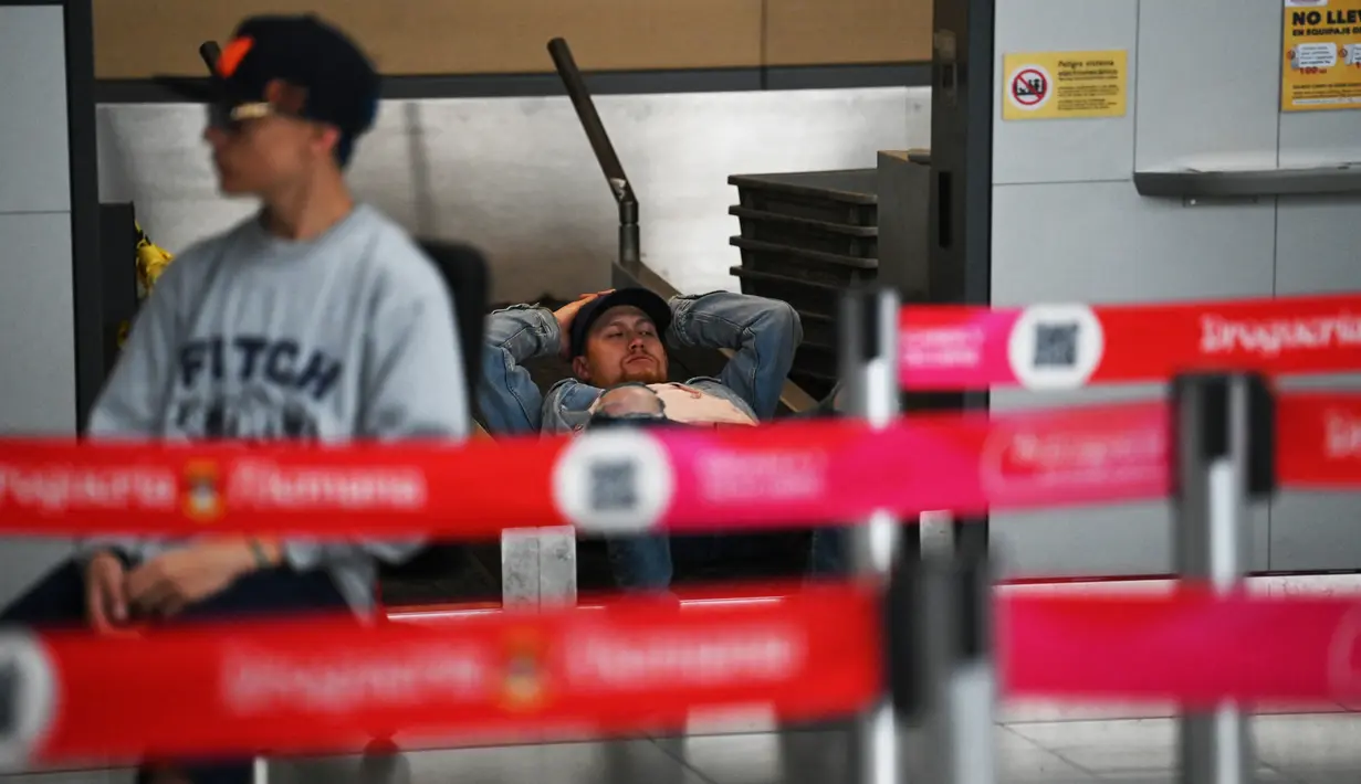 Orang-orang berbaring di lantai setelah penerbangan mereka dengan Maskapai penerbangan bertarif rendah Kolombia Viva Air dibatalkan di bandara internasional El Dorado di Bogota, Selasa (28/2/2023). Perusahaan mengatakan merger adalah satu-satunya jalan keluar dari kesengsaraan keuangan yang disalahkan pada pandemi virus Corona. (Juan Barreto / AFP)