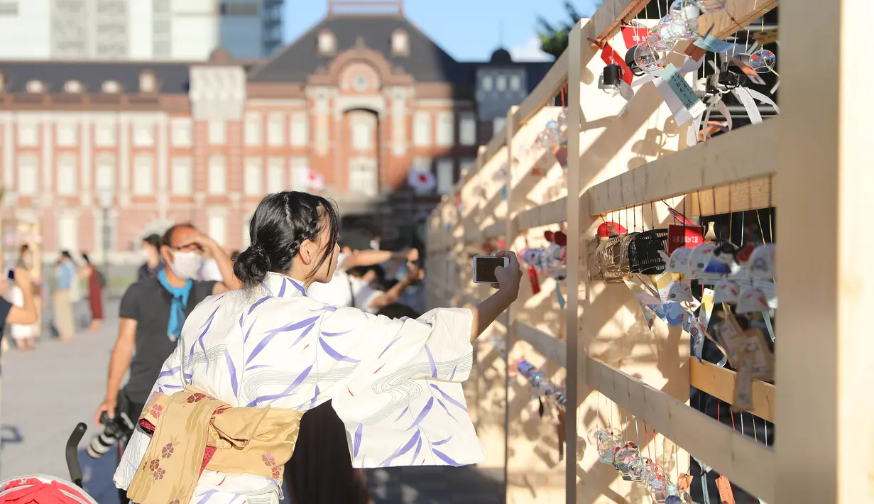Seorang pengunjung memotret lonceng angin di sebuah pameran dekat Stasiun Tokyo di Tokyo, Jepang (26/8/2020). Lebih dari 2.000 lonceng angin dipajang selama pameran yang berlangsung dari 21 Agustus hingga 28 Agustus itu. (Xinhua/Du Xiaoyi)