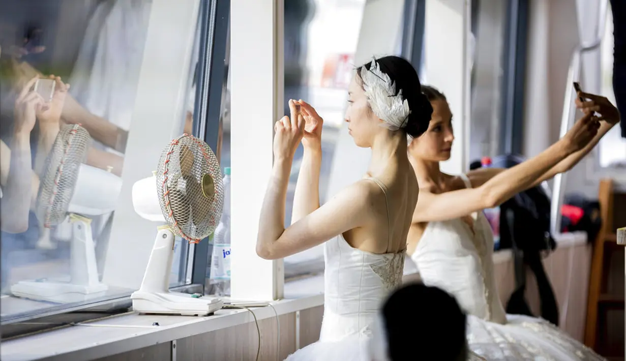 Penari Staatsballett Berlin mengambil foto dari bawah dek di atas kapal pesiar selama tur pusat kota di Berlin, Jerman, Kamis (10/6/2021). Pertunjukan itu diikuti oleh banyak orang di sepanjang rute. (Christoph Soeder/dpa via AP)
