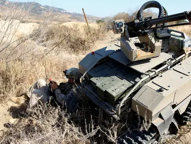 Tentara AS mengendalikan Multi-Utilitas Tactical Transport (MUTT) saat menggelar latihan militer Rim Pasifik (RIMPAC) 2016 di Camp Pendleton, Amerika Serikat, (13/7). MUTT merupakan tank kecil tanpa awak yang super canggih. (REUTERS / Mike Blake)