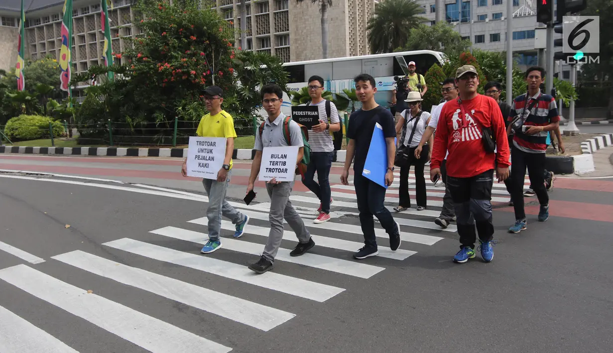 Koalisi Pejalan Kaki melakukan aksi Tamasya Trotoar Kita di Jalan Medan Merdeka Selatan, Jakarta, Minggu (24/6). Kegiatan ini dalam rangka kampanye penyadaran masyarakat tentang fungsi trotoar sebagai fasilitas pejalan kaki. (Liputan6.com/Arya Manggala)