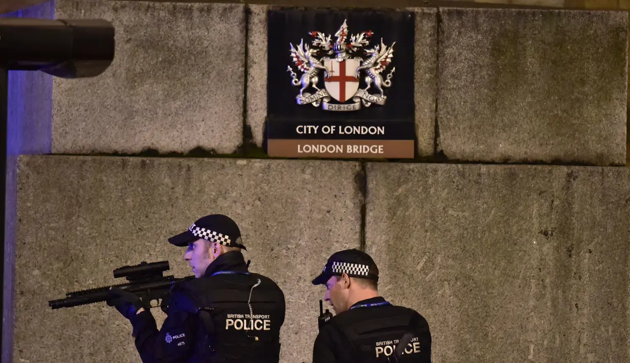 Polisi bersenjata melakukan penjagaan di London Bridge, setelah serangan teror di pusat kota London, Sabtu (3/6). Teror terjadi ketika sebuah mobil van melaju kencang dan menghantam para pejalan kaki yang berada di kawasan itu (Dominic Lipinski/PA via AP)