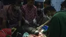 Dokter hewan dan mahasiswa saat melakukan operasi amputasi beruang madu di Banda Aceh (14/6/2019). Anak beruang madu yang diperkirakan berusia 2 tahun lebih tersebut harus diamputasi akibat terkena jerat babi. (AFP Photo/Chaideer Mahyuddin)