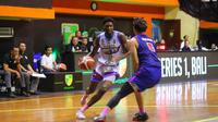 Pemain RJ Amartha Hangtuah Joe-Junior Muezelo saat mencoba dihadang oleh pemain Rans PIK Basketball Oki Wira Sanjaya dalam game terakhir seri 1 IBL 2023 di GOR Merpati Denpasar. (Maheswara Putra/Bola.com)