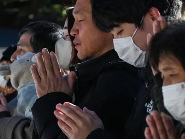 Para pengunjung menengadahkan tangan saat berdoa pada pagi hari pertama tahun baru di Kuil Meiji di pusat kota Tokyo pada tanggal 1 Januari 2025. (Richard A. Brooks/AFP)