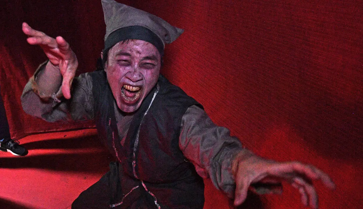 Seorang aktor menggunakan kostum menyeramkan saat preview media 'Halloween Horror Nights' di Universal Studio, Singapura, Senin (24/9). Universal Studio Singapura kembali menggelar acara halloween untuk kedelapan kalinya. (AFP/Roslan RAHMAN)