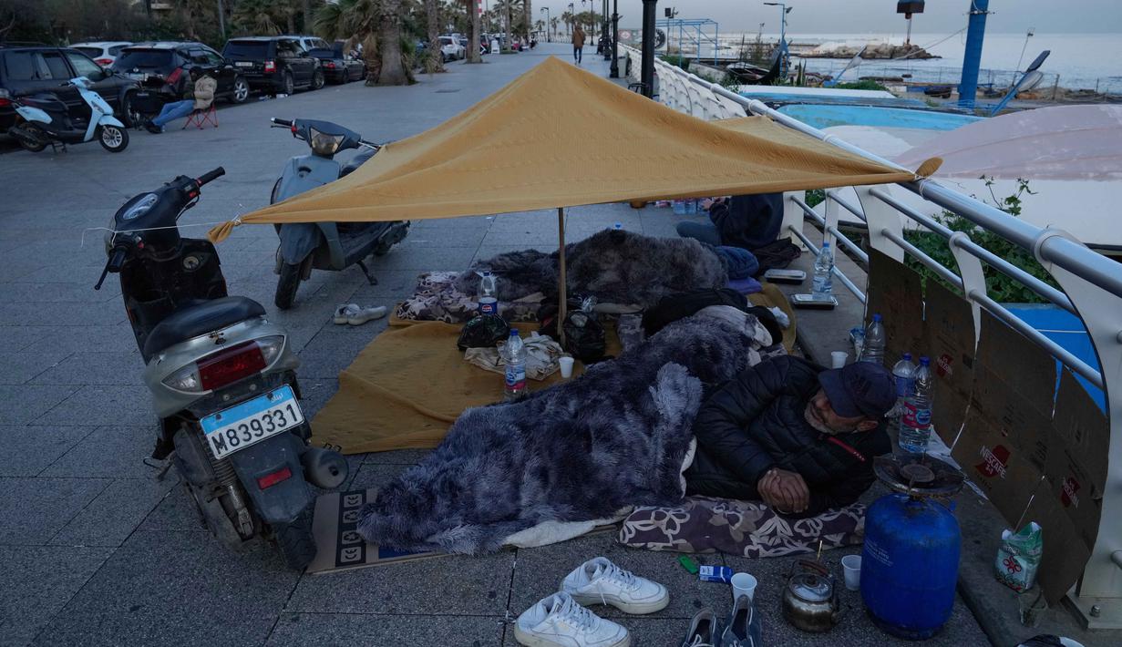 Para pengungsi yang melarikan diri dari serangan udara Israel di Dahiyeh, pinggiran selatan Beirut, beristirahat di tepi pantai Beirut, Lebanon, Jumat 6 Maret 2026. Ratusan orang di Beirut, Lebanon, terpaksa tidur di tepi pantai dan trotoar dengan kondisi seadanya. (AP Photo/Hussein Malla)