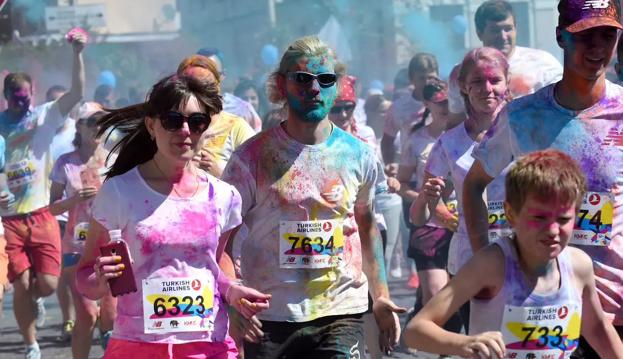 Para peserta berlari dengan dipenuhi bubuk warna-warni saat mengikuti Kyiv Color Run di Kiev, Ukraina, Minggu (10/6). The Color Run diluncurkan dan diselenggarakan pertama kali pada Januari 2012 di Amerika Serikat. (AFP PHOTO/Sergei SUPINSKY)