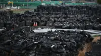Foto ini diambil pada 29 Februari 2020 menunjukkan tanah permukaan yang terkontaminasi radiasi yang dikemas dalam tas hitam di sebuah lapangan di Tomioka, prefektur Fukushima di sebelah utara PLTN Daiichi Daiichi Fukushima yang rusak parah akibat gempa dan tsunami 2011. (AFP/Charly Triballeau)