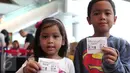 Dua anak memperlihatkan tiket nonton Peanut Snoopy di Blitz Megaplex, Jakarta, Sabtu (12/12/2015). Nonton bareng tersebut diselenggarakan oleh Cinemaholic Liputan6.com bekerjasama dengan Lipton. (Liputan6.com/Angga Yuniar)