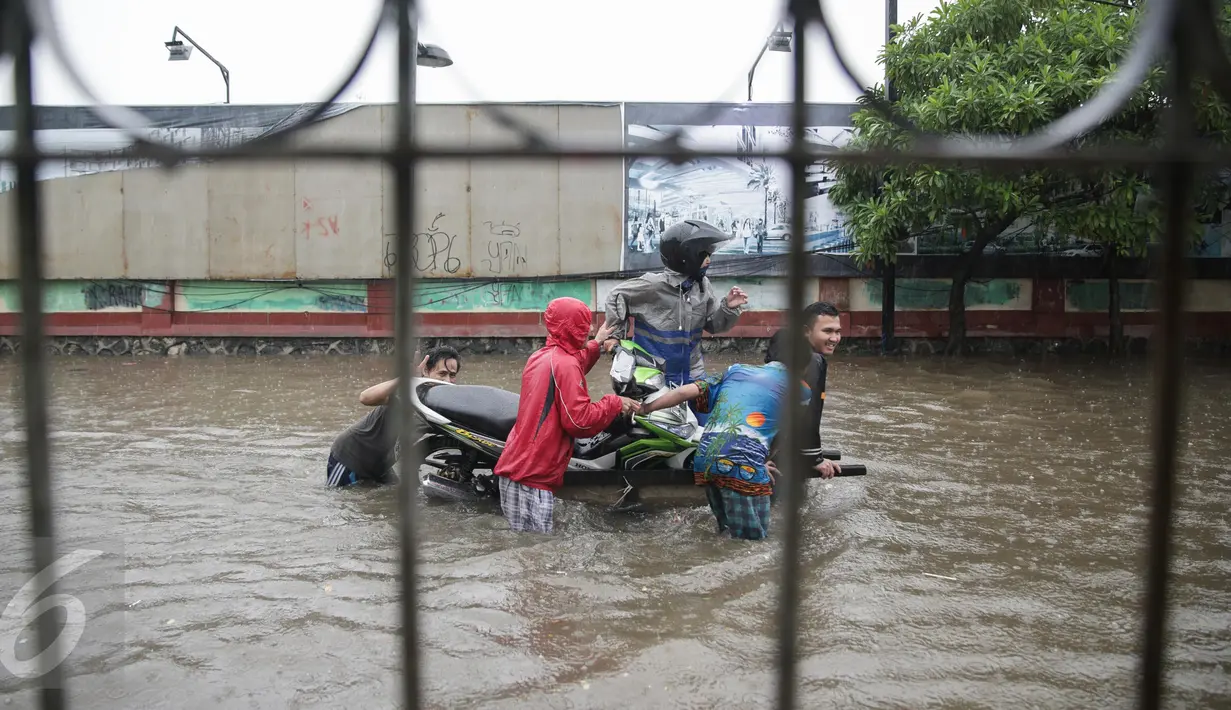 Penyedia jasa gerobak mengangkut warga menerobos banjir yang merendam Jalan Gunung Sahari, Jakarta Pusat, Selasa (21/2). Hujan deras yang mengguyur sejak Selasa dini hari membuat sebagian wilayah di Jakarta banjir. (Liputan6.com/Faizal Fanani)