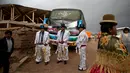 Sejumlah lelaki mengenakan kostum bersiap mengikuti karnaval Anata Andina (Andean karnaval) di Caquiaviri, Bolivia, Selasa (17/1). Dalam acara tersebut sejumlah orang mengenakan kostum dan topeng memenuhi jalan Provinsi Caquiaviri. (AP Photo/Juan Karita)