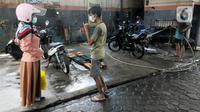 Karyawan penyandang tunarungu berkomunikasi menggunakan bahasa isyarat dengan pelanggannya di Deaf Cafe and Car Wash di kawasan Cinere, Depok, Jawa Barat, Senin (27/9/2021). Seluruh karyawan di tempat cuci mobil-motor dan kafe ini merupakan penyandang tunarungu. (merdeka.com/Arie Basuki)