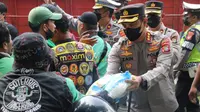 Anggota kepolisian menyerahkan paket sembako kepada mereka yang terdampak kenaikan BBM di Kota Tangerang.