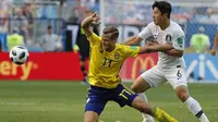 Pemain Swedia, Viktor Claesson (kiri) berebut bola dengan pemain Korea Selatan, Park Joo-ho pada laga grup E Piala Dunia 2018 di Nizhny Novgorod stadium, Nizhny Novgorod, Rusia, (18/6/2018). Swedia menang 1-0. (AP/Pavel Golovkin)