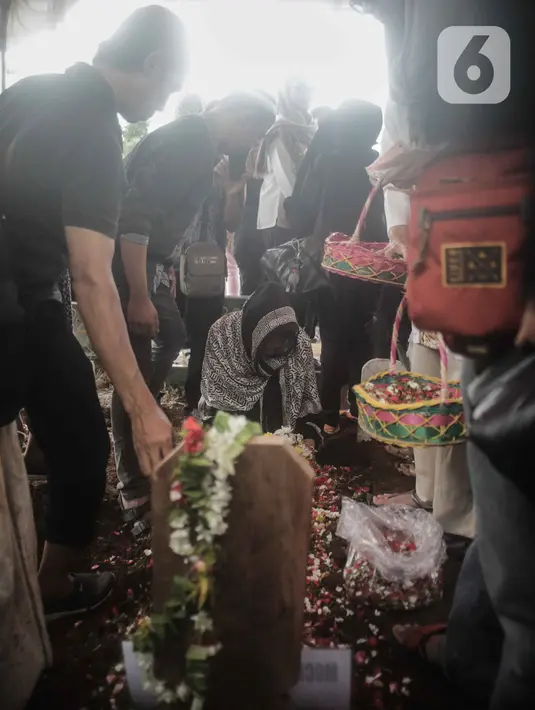 Keluarga menaburkan bunga di atas pusara mantan artis cilik Cecep Reza saat pemakaman di TPU Layur Penggilingan, Jakarta, Rabu (20/11/2019). Cecep Reza meninggal pada usia 31 tahun karena penyakit jantung. (Liputan6.com/Faizal Fanani)