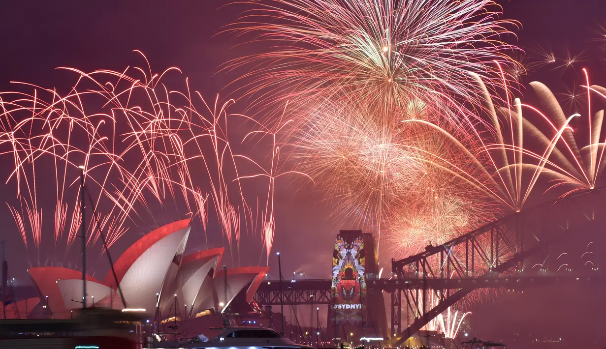 Kembang api memancar di atas Sydney Harbour Bridge dan Opera House saat perayaan Tahun Baru di Australia (1/1/2016). (AFP Photo / Peter Parks)