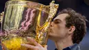 Petenis Inggris Raya, Andy Murray mencium trofi sebagai juara turnamen China Open setelah mengalahkan petenis Bulgaria Grigor Dimitrov, di Beijing, Minggu (9/10). Titel tersebut diraih usai melakoni duel selama satu jam 57 menit. (NICOLAS ASFOURI/AFP)