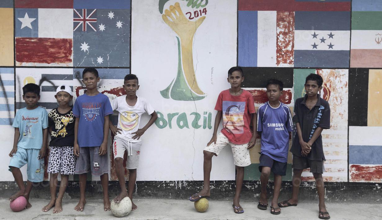 Sebuah mural raksasa bertema Piala Dunia 2014 Brasil mewarnai sebuah sudut di Desa Tulehu, Maluku. Tiap detail kehidupan warga Tulehu memang tidak jauh dari nuansa sepak bola. (Bola.com/Peksi Cahyo)