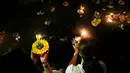 Dua wanita Thailand bersiap menghayutkan 'krathong' untuk merayakan festival Loy Krathong di sebuah danau di Bangkok, Kamis (22/11). Loy Krathong adalah ritual melarung wadah berbentuk lotus yang didalamnya diberi sesajen, lilin dan dupa (Jewel SAMAD/AFP)