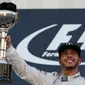 Pebalap Mercedes Lewis Hamilton mengangkat trofi usai memenangkan Formula 1 GP Jepang di Sirkuit Suzuka, Minggu (27/9/2015). (Liputan6.com/REUTERS/Thomas Peter)