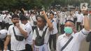 Massa dari Forum Komunikasi Nakes dan Non-Nakes Indonesia (FKHN Indonesia) menyampaikan tuntutan saat menggelar aksi di kawasan Patung Kuda, Jakarta Pusat, Kamis (22/9/2022). Beberapa di antaranya membawa atribut seperti bendera, slayer, spanduk, hingga poster yang bertuliskan protes hingga tuntutan kepada pemerintah. (Liputan6.com/Herman Zakharia)